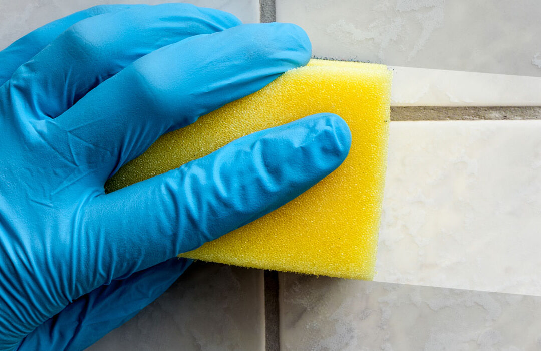 hand sponge wiping tile